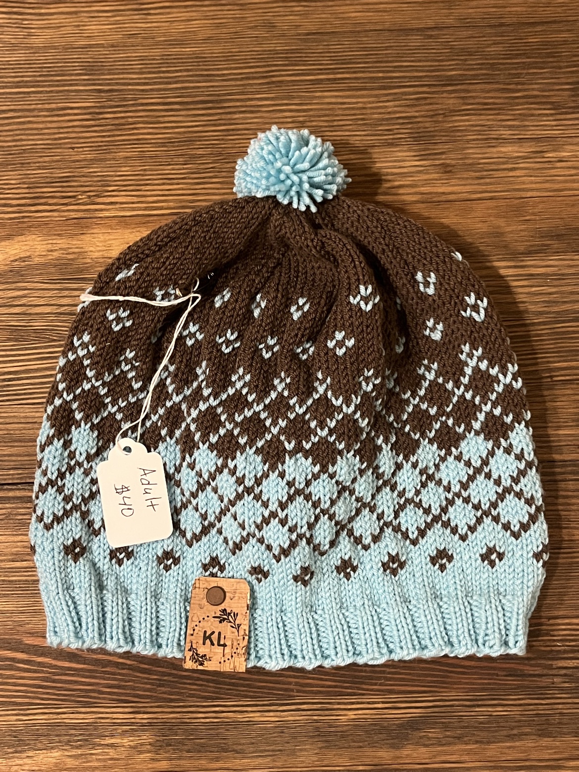 Adult hand knit wool hat in teal and brown with a teal pom-pom