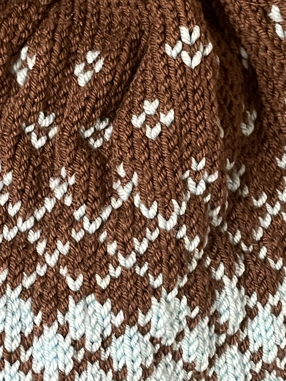 Close-up of the teal and brown knit pattern