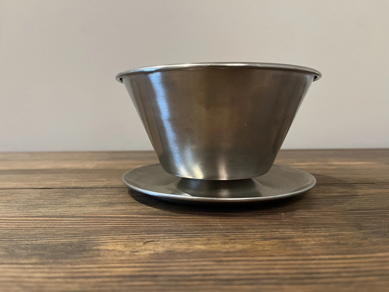 Stainless steel bowl with a tapered edge and attached matching underplate