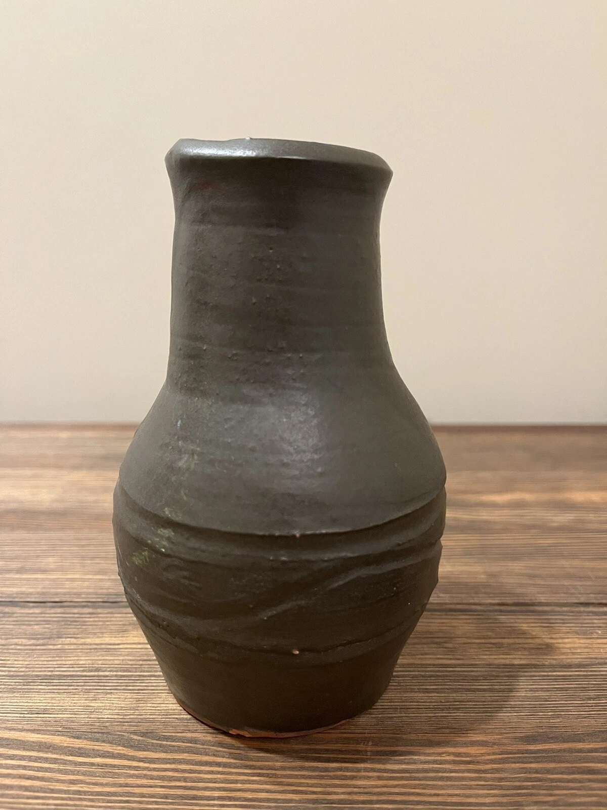 Matte brown studio pottery vase with a flared rim and subtle swirl pattern