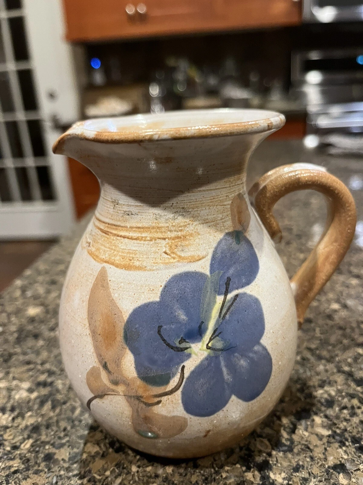 Brown and tan Vallauris France pitcher with a large blue floral detail