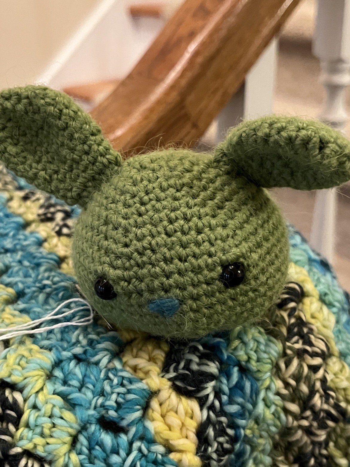 Close-up of the lovie’s moss-green crochet bunny face and ears