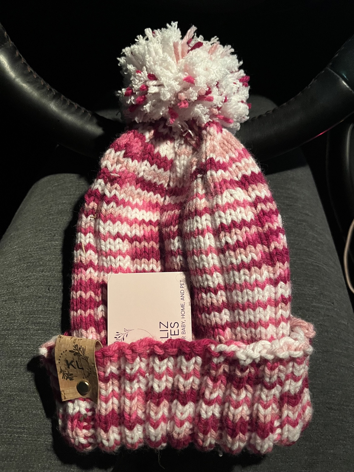 Pink and cream hand-knit pom-pom hat with a folded brim