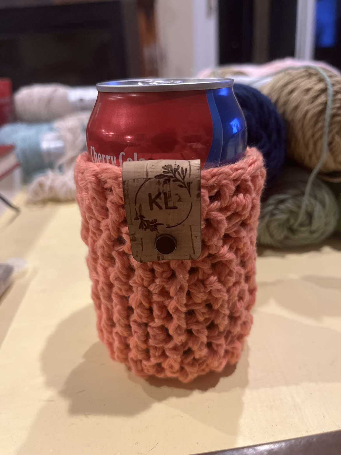 Pink crocheted drink holder with a bear face