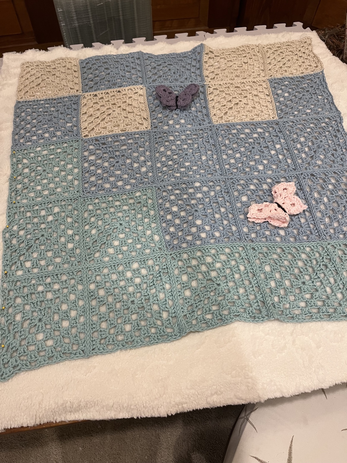 Blue, sage, and cream crocheted patchwork blanket with butterfly accents