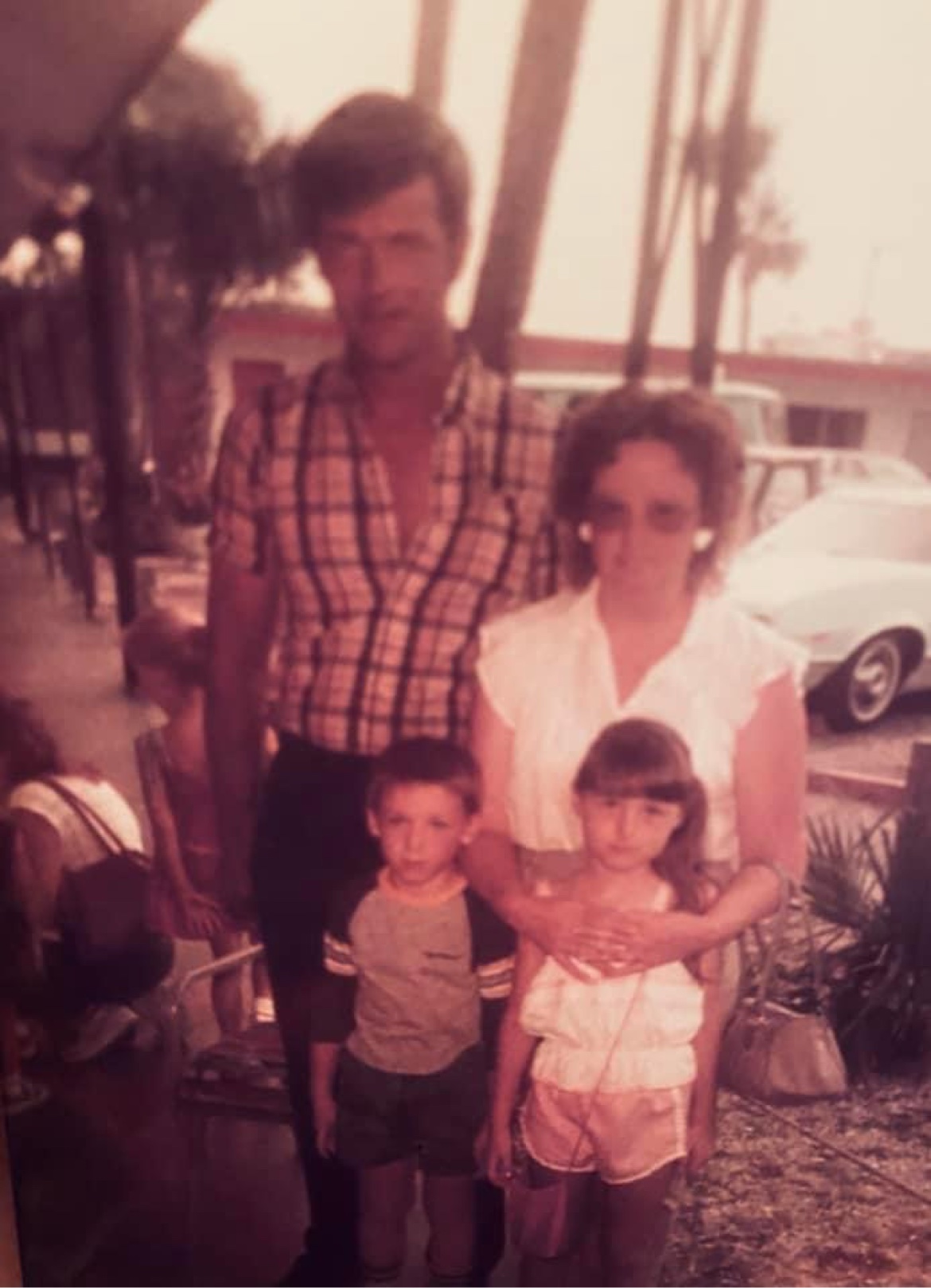 Vintage family photograph of two adults and two children standing outdoors