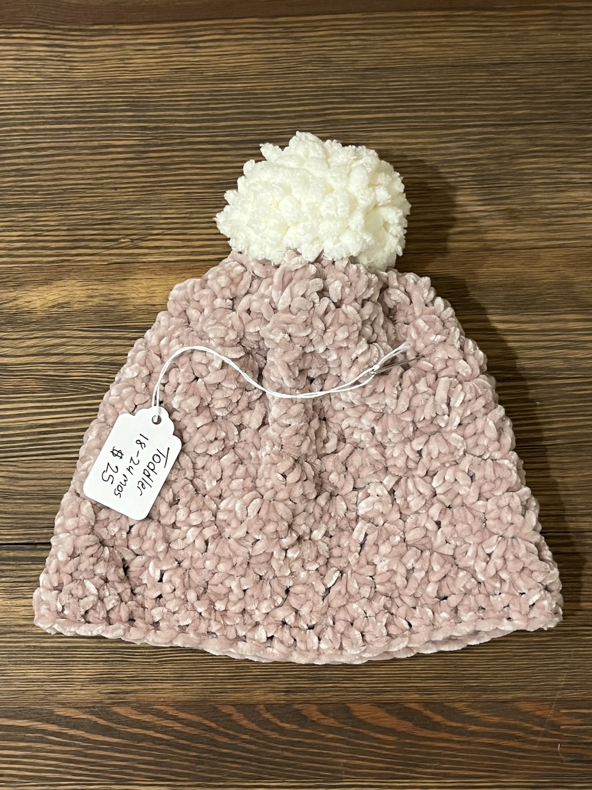 Pink crochet toddler hat with a white Pom Pom