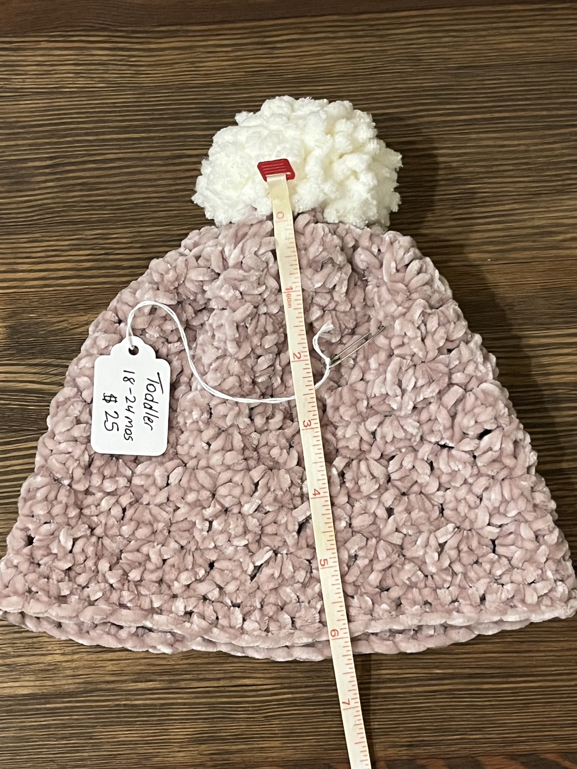 Crochet toddler hat shown with a measuring tape from Pom Pom to brim