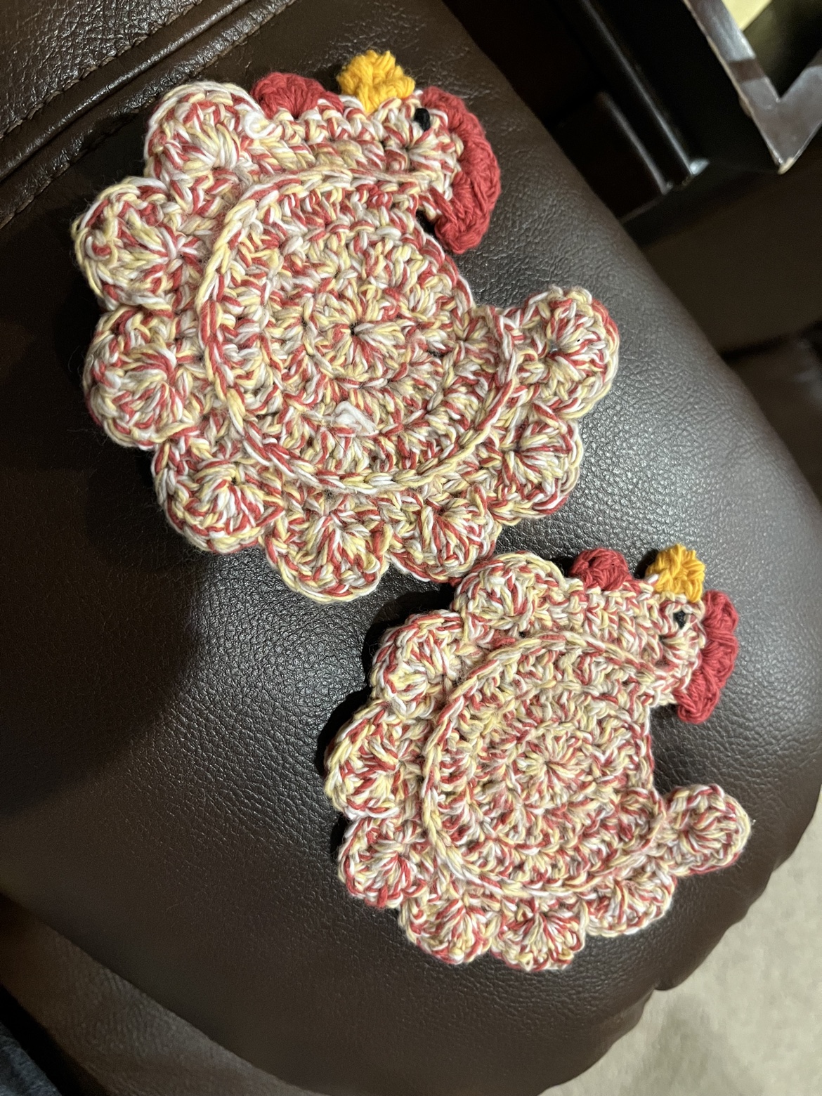 Pair of cream and red crocheted chicken trivets