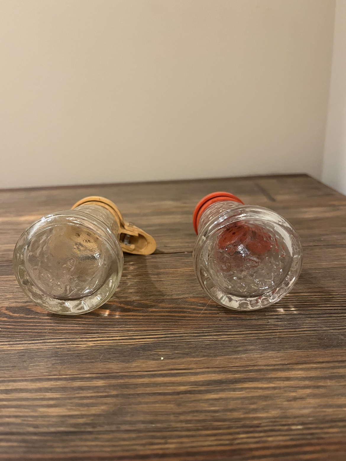 Bottom view of both glass shakers in the vintage salt and pepper set
