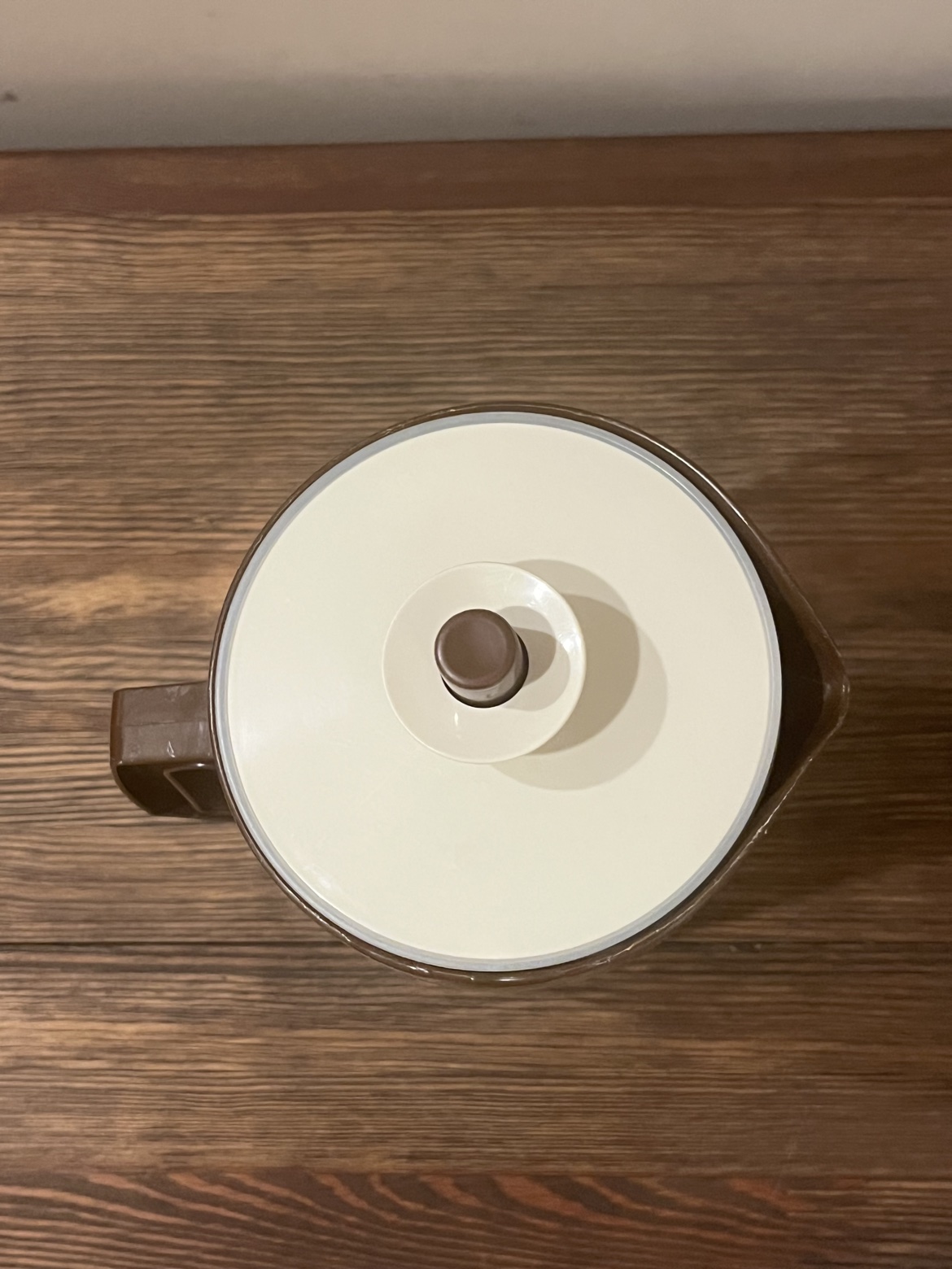 Top-down view of the cream lid with brown knob